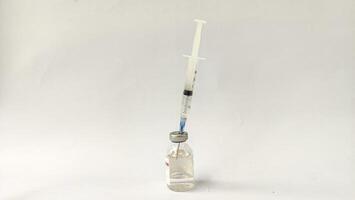 Vial of Drug or Vaccine and 3 ml Plastic Syringe with Needle Isolated on the White Background, blue tone color photo