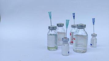 Vial of Drug or Vaccine and 3 ml Plastic Syringe with Needle Isolated on the White Background, blue tone color photo