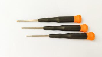 Set of red-orange-blue screwdrivers isolated on white background. Builder's and electrician's tools. Equipment. Set of steel screwdriver bits with red and black plastic handles. photo