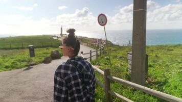 Enjoying a Scenic Coastal Walk with a Person Dressed in a Casual Checkered Shirt video