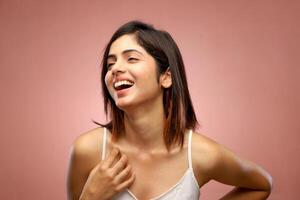 Alluring Woman in White Crop Top Posing With Her One Hand on Waist and Other Hand on Chest photo