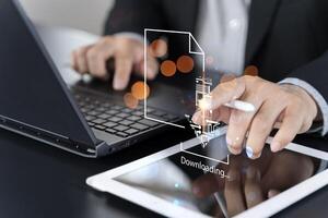 Business man downloading computer files or installing software on laptop computer, cloud storage technology photo