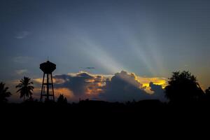 Silhouette of water tower at sunset time in the evening. photo