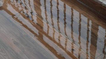 Rainwater collects on wooden surface creating tranquil reflections video