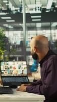 Vertical Employee having online discussion with coworkers in call meeting, working from office. Staff member in conference over the internet with teleworking colleagues, camera B video