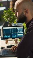 Vertical Employee in office celebrating achievement while looking at laptop screen, expressing excitement over successful results. Man happy about positive business accomplishment, camera A video