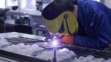 Man wearing mask welding in a workshop. Metal workers use manual labor. Skilled welder. Welder is welding the stainless steel pipes in the factory. welder Industrial part in factory. 14 video