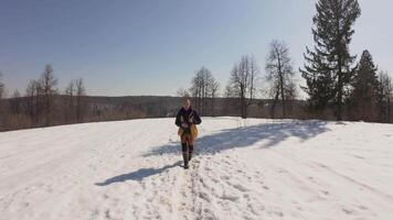 A person walking in the snow on a hill video