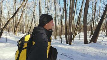 A man with a yellow backpack in the woods video