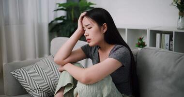 Handheld shot, Stressed woman sits alone on a sofa, thinking aimlessly, feeling worried about something. Life problems video