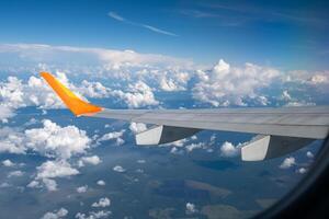 View from airplane window on wing and landscape with clouds on window during flight. photo