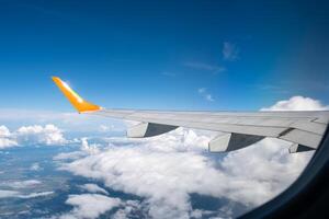 View from airplane window on wing and landscape with clouds on window during flight. photo