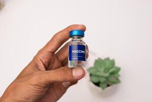 doctor's hand holds a bottle of vaccine injection. health and medical concepts photo
