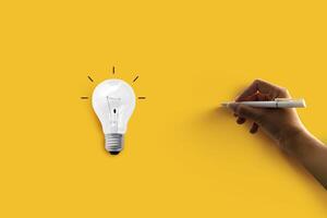 Light bulb on yellow background with the handwriting on the empty space. Earth Day Concept photo