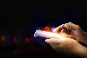 a person holding a cell phone with a light on it photo