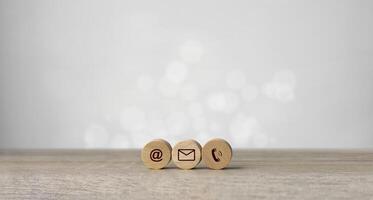 Wooden with contact icons on the table. symbol of connection, email telephone, and dialog box. Technology social network. photo