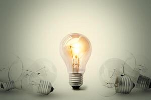 One shining light bulb in the middle between many light bulb. Conceptual different thinking or leadership. photo