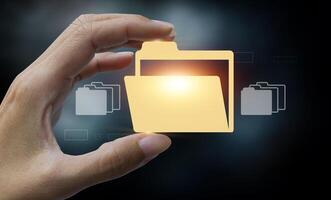 hand holding folder with file icons on dark background photo