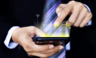 a man in a suit is holding a smartphone with a cloud icon on it photo