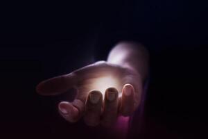a person holding a glowing light in their hand photo