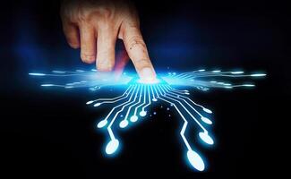 a finger touching a glowing circuit board photo