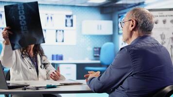 Old man receiving bad news of a dangerous disease diagnosis from his medic, discussing with physician about treatment. Worried distraught patient getting concerned of wellbeing. Camera A. video