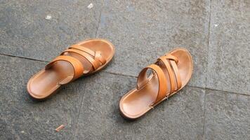 Brown sandals isolated on a cement floor background. photo