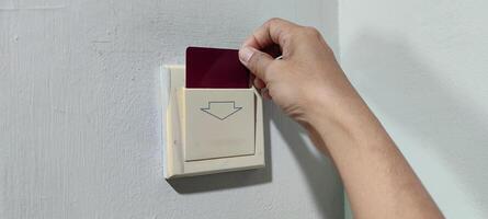 inserting a card key into a switch in a modern hotel room during the day photo