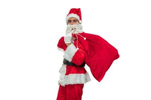 Santa Claus seen from the side holding a sack of gifts while looking at the camera white background photo