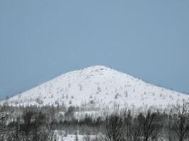 White snow covered the top of the hill on blue sky background. photo