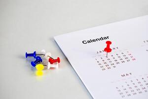 red pin stack in calendar on table photo