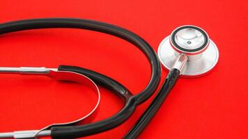 Professional stethoscope on a red background signifying medical examination and healthcare photo
