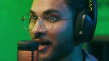 Carefree happy talking to mic working at radio studio man microphone talk podcast live stream call game influencer communicate distant male guy in neon light streaming streamer gamer playing video
