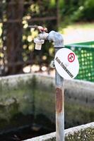 Old outdoor faucet with warning sign Not for drinking water photo