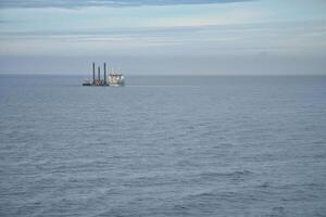 Offshore drilling platform in the open sea under a cloudy sky. photo