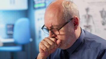 Specialist consulting patient with physical disability and a cough, discussing about treatment against respiratory discomfort. Medic helping senior man with advice, wheelchair user. Camera B video