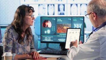 Healthcare professional sharing his expertise and interpreting the MRI scans results, offering advice and support to sick woman at checkup. Accurate diagnostics and patient care. Camera B. video
