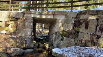 A Stone Bridge gracefully spanning a Stream in a beautiful Nature Scene, filled with serenity photo