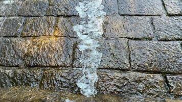 The Flowing Water Moving Over a Smooth Stone Surface Within a Beautiful Natural Environment photo