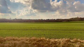 A Beautiful, Expansive Green Field Spreading Beneath a Partly Cloudy and Vibrant Sky Above photo