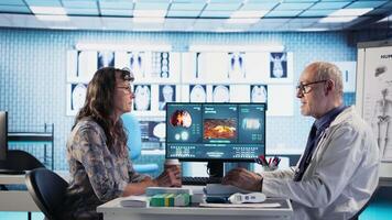 Medical consultation on tumor screening takes place with specialist and elderly patient, medic recommending early detection and lifestyle adjustments for cancer prevention. Camera A. video