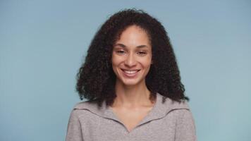Smiling woman nodding in approval gesture on blue background video