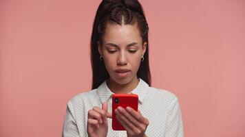 Happy woman reading good news on phone on pink background video