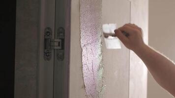 Worker applies decorative plaster with a thin spatula. Giving a unique texture to white walls. Venetian plaster video