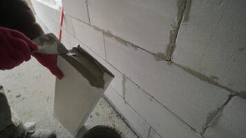 The master performs laying a wall of gas blocks with tools and adhesive mortar 4 video
