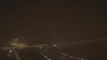 A drone over a lit city at night with a bright TV tower. A cloudless summer night. video