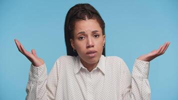 Confused woman shrugging with uncertain expression on blue video