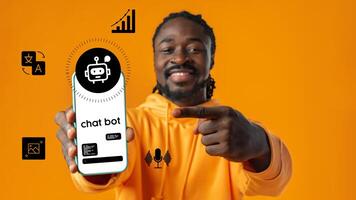 Man showcasing chatbot app on smartphone while standing against vibrant orange background photo
