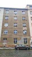 Prague, czech republic - september 16, 2024 Gray building with white windows and parked car in prague photo