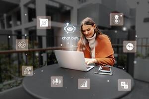Woman working on laptop outdoors while interacting with chatbot icons in a modern setting photo